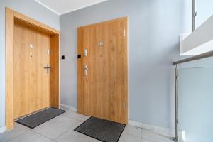 Una habitación con dos puertas de madera y esteras. en Apartament Grunwaldzka 35, en Olsztyn
