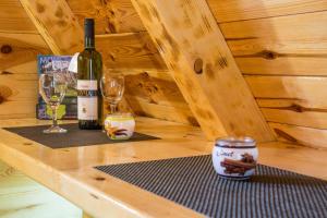 een houten tafel met twee glazen en een fles wijn bij Cottage Danilo in Žabljak