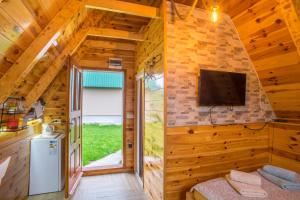 una habitación con TV en una cabaña de madera en Cottage Danilo en Žabljak