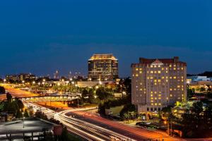 Sheraton Suites Galleria Atlanta في أتلانتا: أفق المدينة في الليل مع المباني والزحمة
