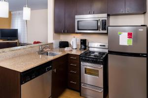 uma cozinha com um frigorífico de aço inoxidável e um lavatório em TownePlace Suites Huntington em Huntington