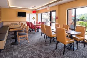 a dining room with tables and chairs and a table at TownePlace Suites Huntington in Huntington