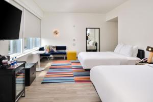 a hotel room with a bed and a living room at Aloft Charlotte Airport in Charlotte