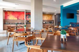 un restaurant avec des tables et des chaises en bois dans l'établissement Fairfield Inn & Suites by Marriott Aguascalientes, à Aguascalientes