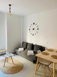 - un salon avec un canapé et un réveil sur le mur dans l'établissement Apartment Rosario in Malaga center, à Malaga