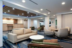 a lobby with a couch and chairs and a table at Fairfield Inn & Suites by Marriott Atlanta Stonecrest in Lithonia