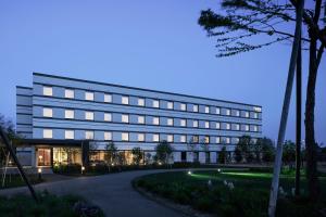 - un grand bâtiment blanc avec des lumières devant dans l'établissement Fairfield by Marriott Hokkaido Eniwa, à Eniwa