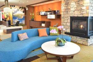 - un canapé bleu dans le salon avec cheminée dans l'établissement Fairfield Inn & Suites by Marriott Eau Claire/Chippewa Falls, à Eau Claire