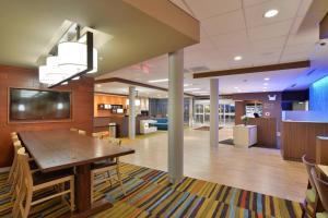 Fairfield Inn & Suites by Marriott Eau Claire/Chippewa Falls في أو كلير: قاعة اجتماعات مع طاولة خشبية وتلفزيون