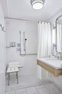 a white bathroom with a sink and a shower at Annapolis Waterfront Hotel, Autograph Collection in Annapolis