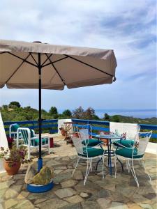 a patio with a table and chairs and an umbrella at I GABBIANI in Pefkohori