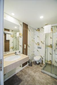 ein Badezimmer mit Badewanne, Toilette und Waschbecken in der Unterkunft UPTOWN Büyük Anadolu Girne Hotel in Kyrenia