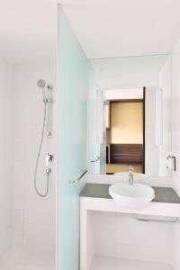 a white bathroom with a sink and a shower at Fairfield by Marriott Ahmedabad in Ahmedabad