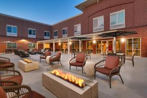 a patio with chairs and a fire pit in front of a building at Courtyard by Marriott Atlanta Duluth Downtown in Duluth