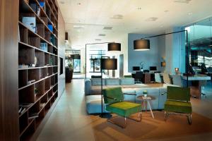 a living room with a couch and a table and chairs at Courtyard by Marriott Gdynia Waterfront in Gdynia