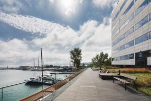 a walkway next to a building with boats in the water at Courtyard by Marriott Gdynia Waterfront in Gdynia