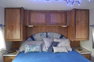 a bedroom with a blue bed with wooden cabinets at The blue rooster 