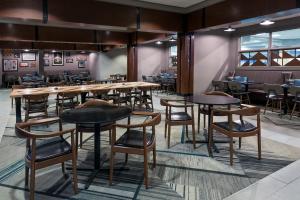 a dining room with wooden tables and chairs at Four Points Huntsville Airport in Madison