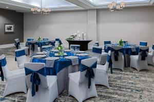 a room with blue and white tables and chairs with blue bows at Four Points Huntsville Airport in Madison