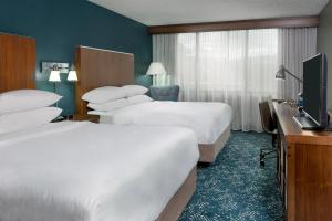 a hotel room with two beds and a television at Four Points Huntsville Airport in Madison