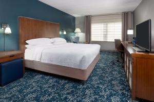 麥迪遜的住宿－福朋亨茨維爾機場酒店，配有一张床和一台平面电视的酒店客房