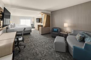 a hotel room with a bed and a couch at Courtyard by Marriott Seattle Northgate in Seattle