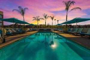 a swimming pool with chairs and umbrellas at a hotel at Courtyard by Marriott Marina del Rey in Los Angeles