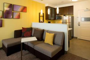 a living room with a couch and a kitchen at Residence Inn by Marriott Omaha Aksarben Village in Omaha