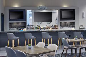 un restaurante con mesas y sillas y un bar en Delta Hotels by Marriott Detroit Novi, en Farmington Hills