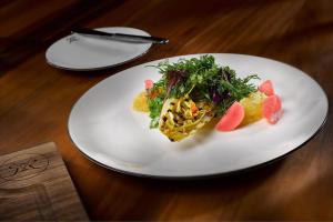 a white plate with food on a wooden table at Villa Rothschild, Autograph Collection in Königstein im Taunus