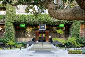 a building with chairs and umbrellas in front of it at W Los Angeles – West Beverly Hills in Los Angeles