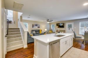 an open kitchen and living room with a staircase at Modern Woodlands Townhome with Spacious Yard and Patio in The Woodlands
