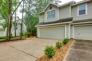a house with two garage doors and a driveway at Modern Woodlands Townhome with Spacious Yard and Patio in The Woodlands