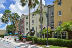 - une vue sur la rue d'un bâtiment avec des palmiers dans l'établissement TownePlace Suites Miami West Doral Area, à Miami