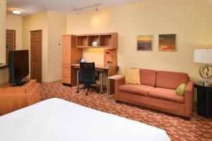 Habitación de hotel con cama, sofá y escritorio en TownePlace Suites Miami West Doral Area en Miami