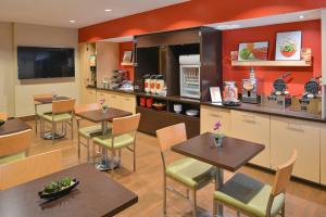 a restaurant with tables and chairs and a counter at TownePlace Suites Miami West Doral Area in Miami