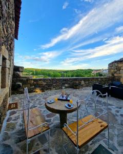 - une table et deux chaises sur une terrasse avec vue dans l'établissement Sweet Côa, à Sabugal