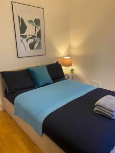 - une chambre avec un lit bleu et 2 oreillers dans l'établissement 2 Bedroom Flat in Camberwell Green - Central Location with excellent connections to tourist attractions and main London airports, à Londres