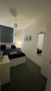 una camera con letto e specchio di 2 Bedroom Flat in Camberwell Green - Central Location with excellent connections to tourist attractions and main London airports a Londra