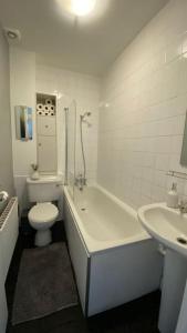 La salle de bains est pourvue d'une baignoire, de toilettes et d'un lavabo. dans l'établissement 2 Bedroom Flat in Camberwell Green - Central Location with excellent connections to tourist attractions and main London airports, à Londres