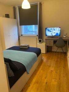 a bedroom with a bed and a desk and a television at 2 Bedroom Flat in Camberwell Green - Central Location with excellent connections to tourist attractions and main London airports in London