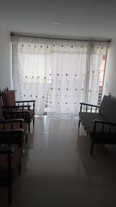 een kamer met een rij stoelen en gordijnen bij casa 4 cocorna in Cocorná