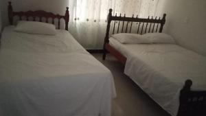 two beds sitting next to each other in a bedroom at casa 4 cocorna in Cocorná