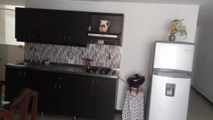 a kitchen with a white refrigerator and a microwave at casa 4 cocorna in Cocorná +3 photos