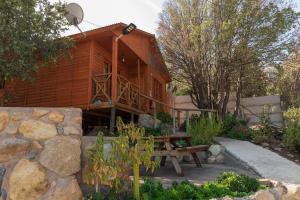 a wooden house with a picnic table in front of it at Cabañas Lomas del Manzano in San José de Maipo