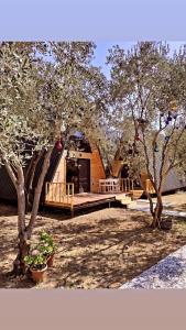 Cabaña de madera con terraza y algunos árboles en GÖCEK BUNGALOW en Göcek