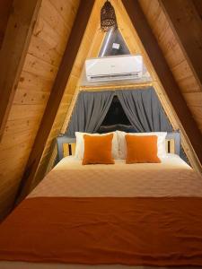 ギョジェクにあるGÖCEK BUNGALOWのテント内のベッド(オレンジ色の枕2つ付)