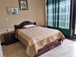 ein Schlafzimmer mit einem Bett, einer Kommode und einem Fenster in der Unterkunft HOTEL 4 RIOS in Cuenca