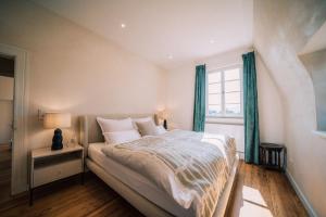 a bedroom with a large bed and a window at Gut Försterlay - Exklusive Boutique Apartments im historischen Winzerhaus direkt an der Mosel in Lösnich +79 photos