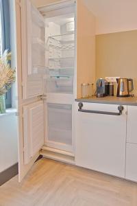 a kitchen with an empty refrigerator with its door open at PRIVATE APPARTMENT 60m2 - CENTRE TOP LOCATION in Amsterdam